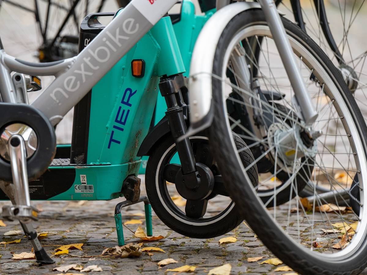 E-Tretroller des Anbieters Tier und ein Leihfahrrad von Nextbike stehen nebeneinander auf einem Gehweg.