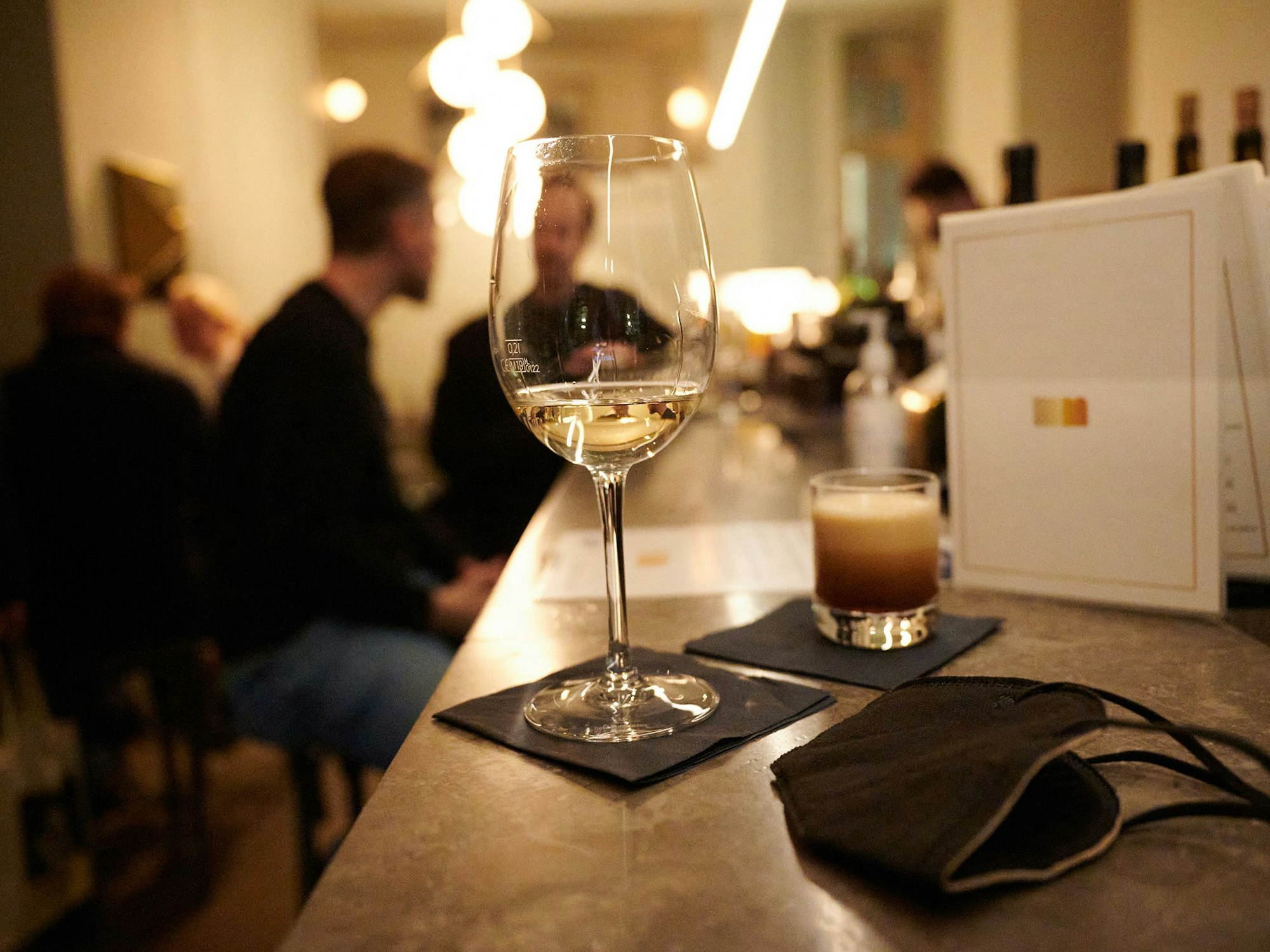 Das Symbolbild zeigt zwei Drinks und eine FFP2-Maske, die auf dem Tresen einer Berliner Bar liegen. Das Foto steht in keinem direkten Zusammenhang zu dem Fall in Weiden.