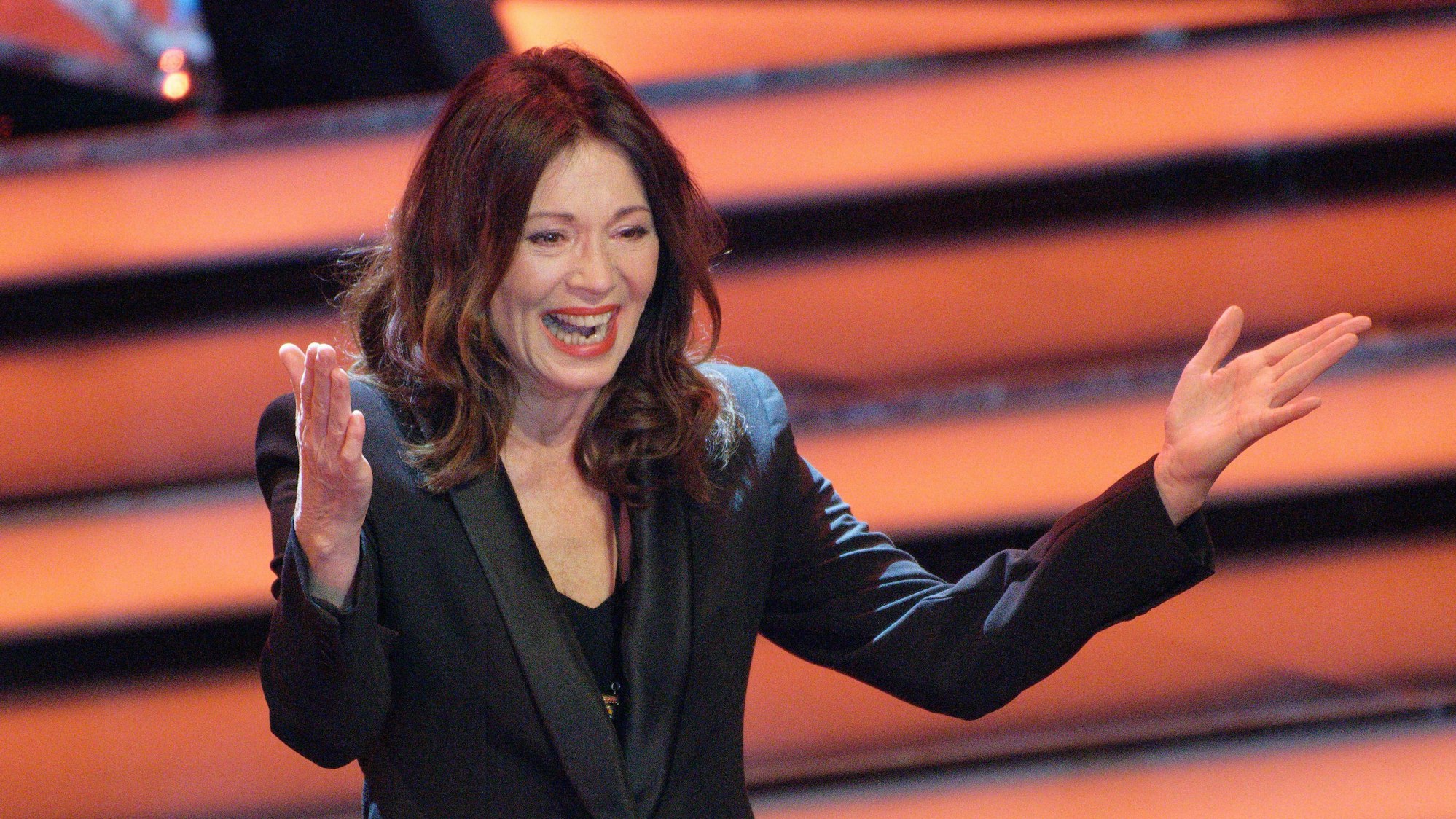 Iris Berben freut sich und breitet die Arme aus.