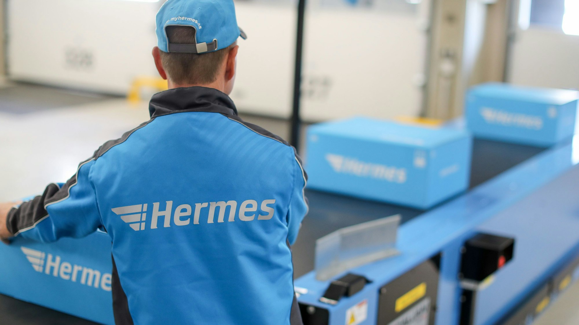 Ein Mitarbeiter demonstriert die Abläufe im Hermes Logistik-Center in Leipzig.