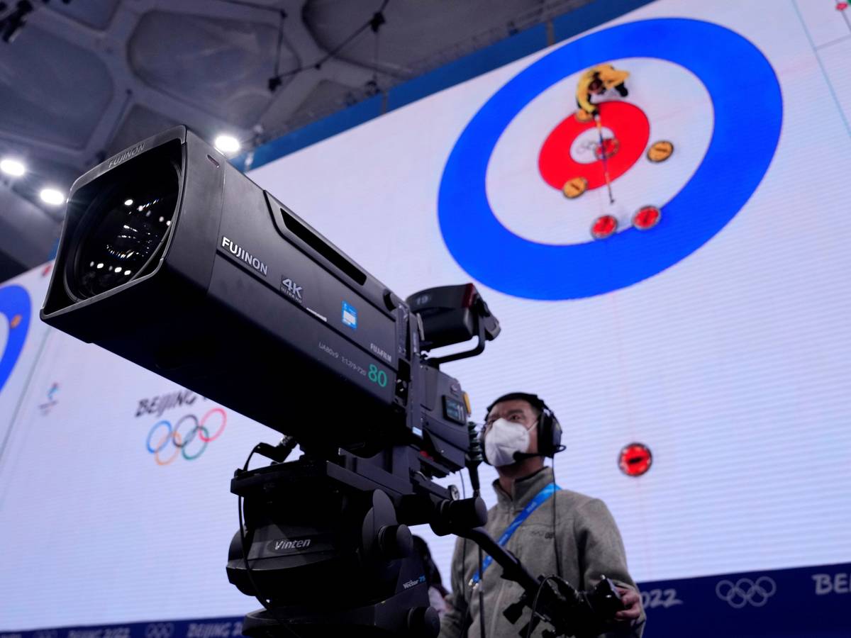 Ein Kameramann steht bei der Olympia-Übertragung der Curling-Halbfinals in Peking vor seinem Arbeitsgerät.