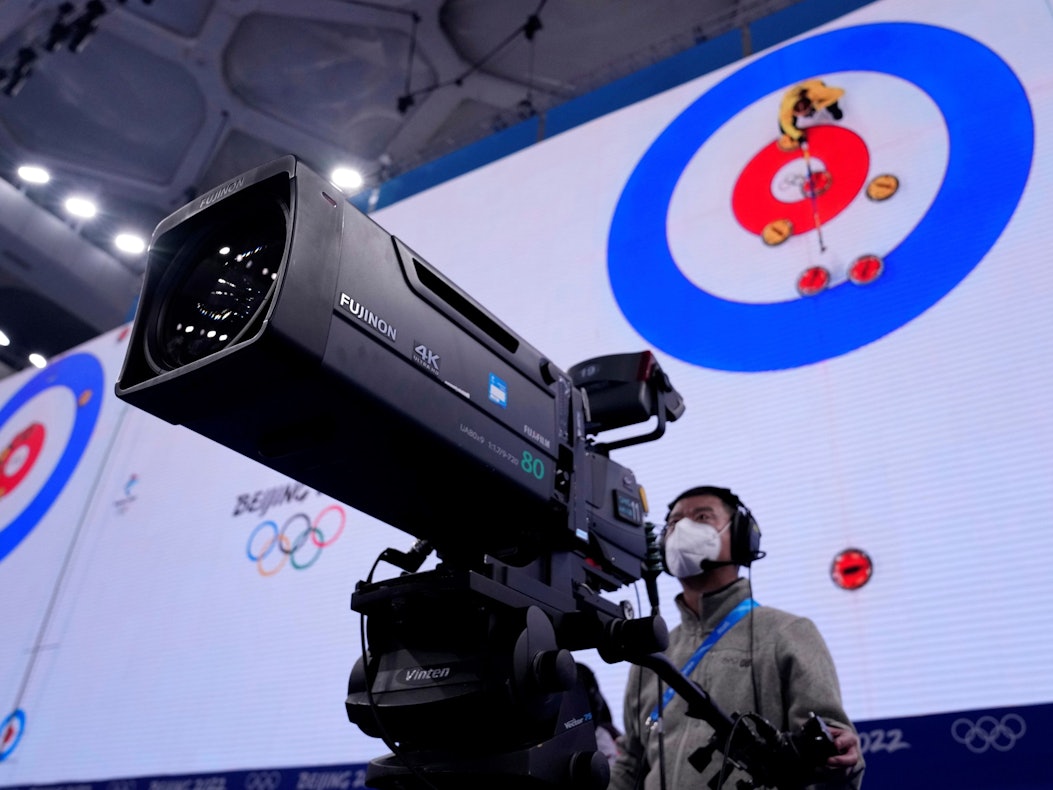Ein Kameramann steht bei der Olympia-Übertragung der Curling-Halbfinals in Peking vor seinem Arbeitsgerät.