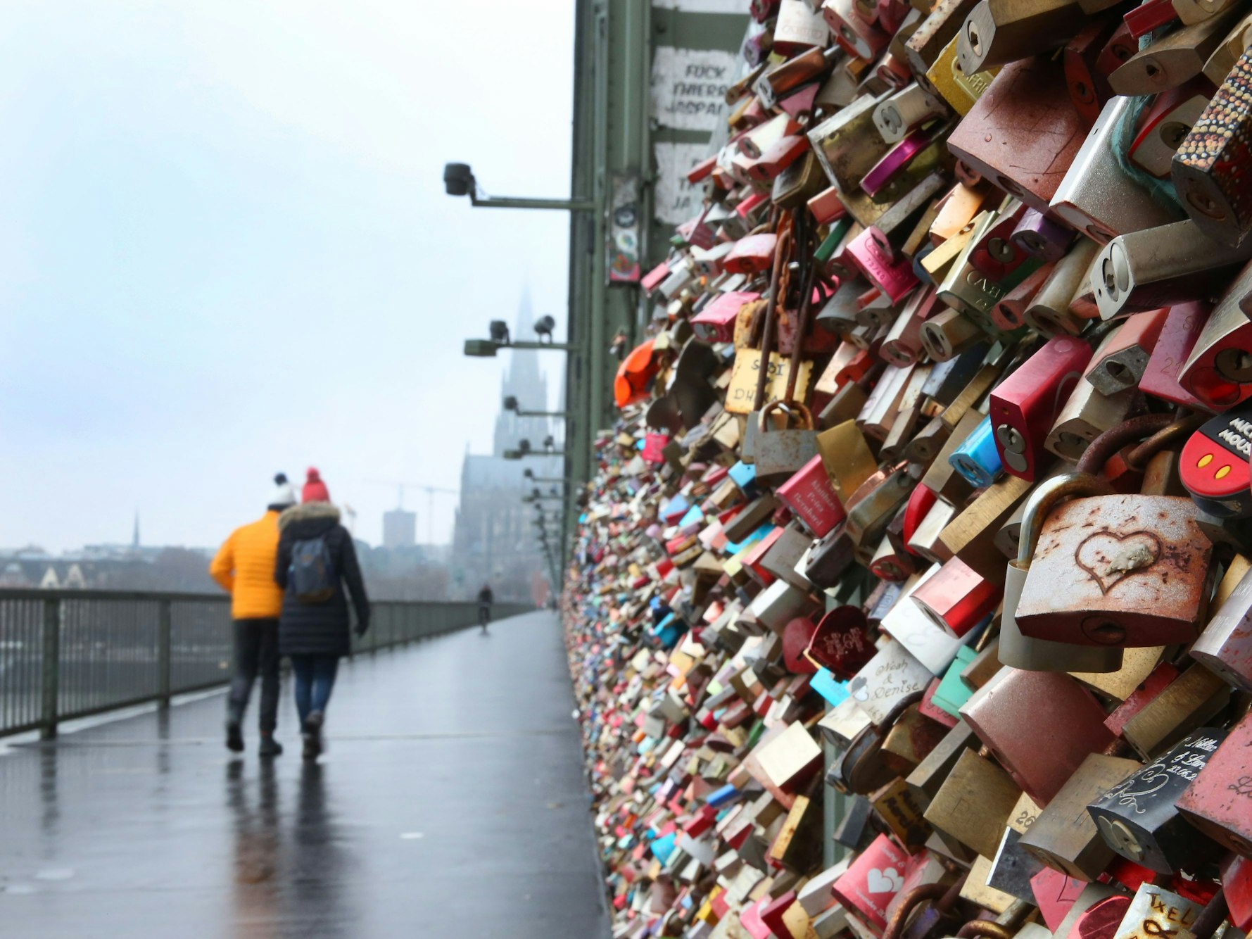 Ein Pärchen läuft über die Kölner Hohenzollernbrücke.