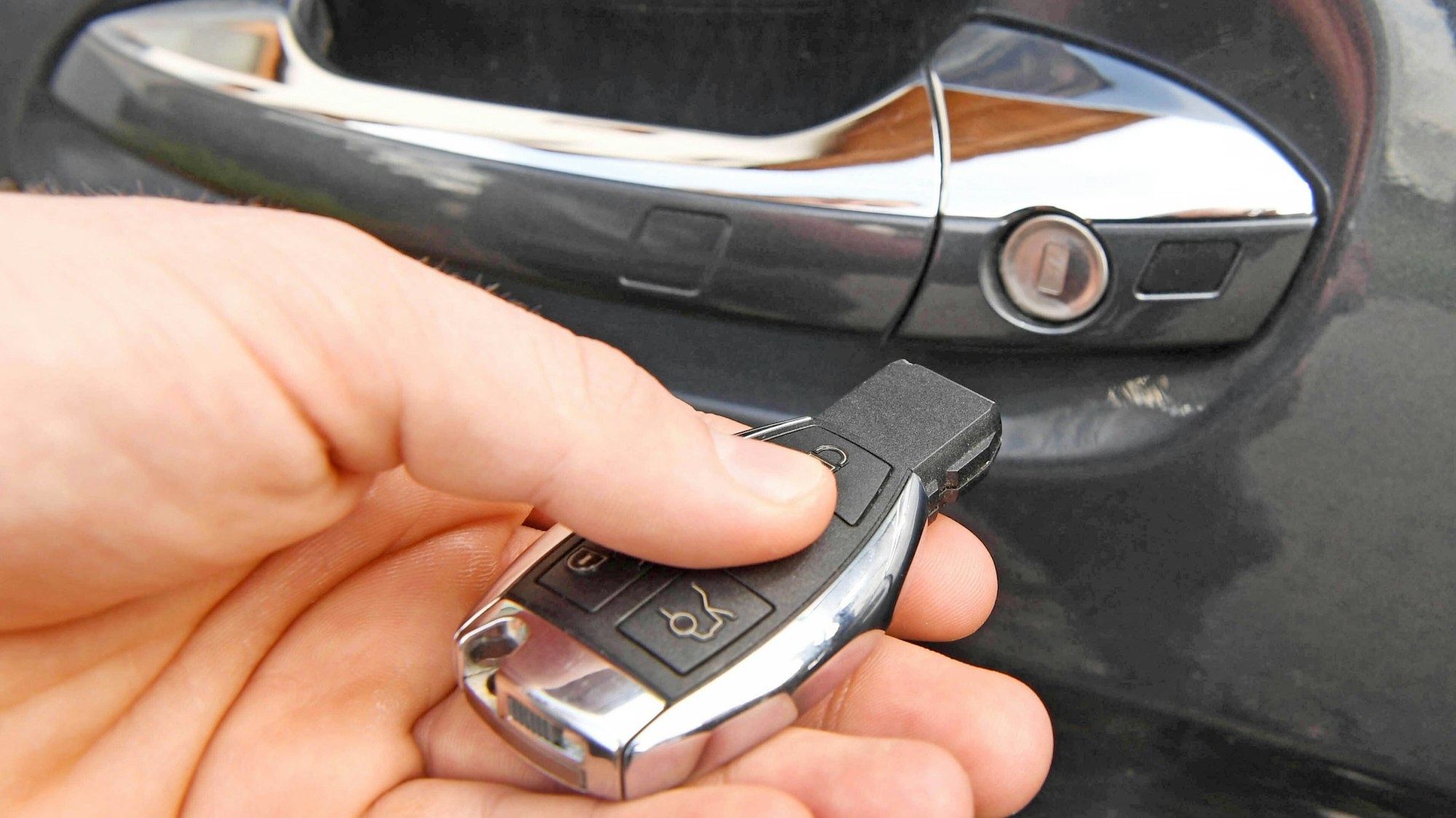 Ein Mann hält einen Autoschlüssel in der Hand.