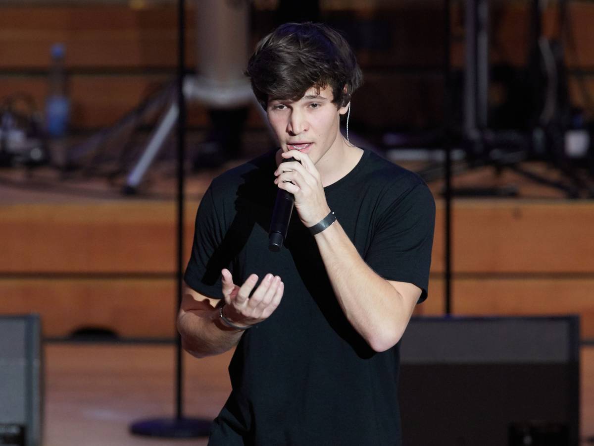 Wincent Weiss, Pop-Sänger, steht zum weltweit ersten Facebook-Weihnachtskonzert auf der Bühne in der Laeiszhalle. Dabei hält er sich ein Mikrofon vor den Mund und gestikuliert mit der rechten Hand.