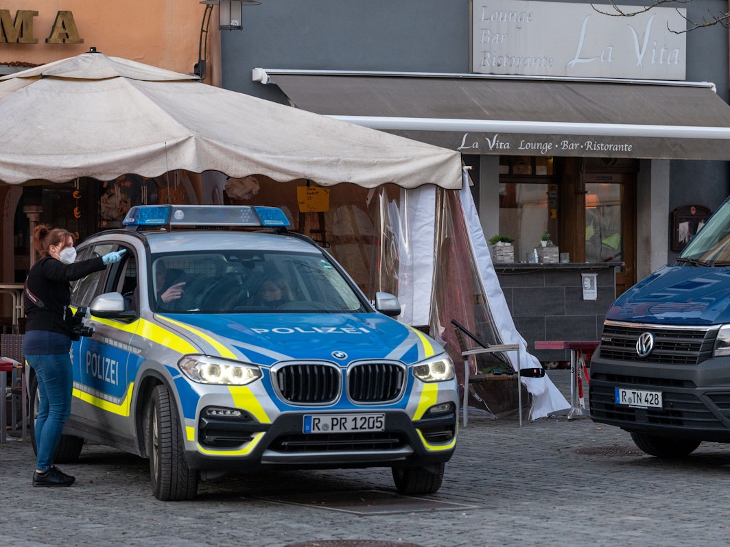 Polizeifahrzeuge stehen vor einem Lokal in der Innenstadt. Nach einem Restaurantbesuch ist ein 52-Jähriger möglicherweise an einer Vergiftung gestorben.