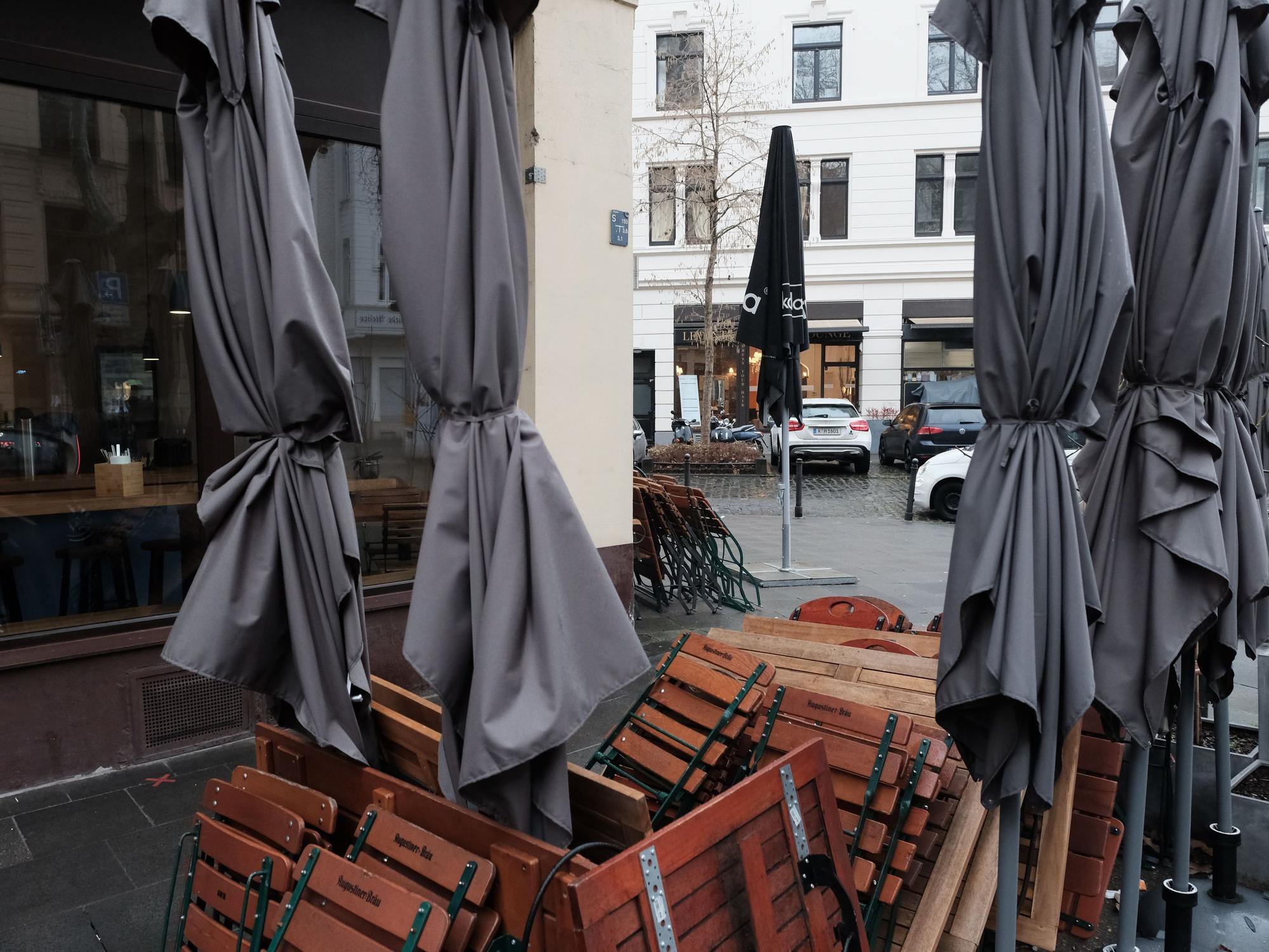 Zusammengeklappte Tische, Stühle und Schirme.