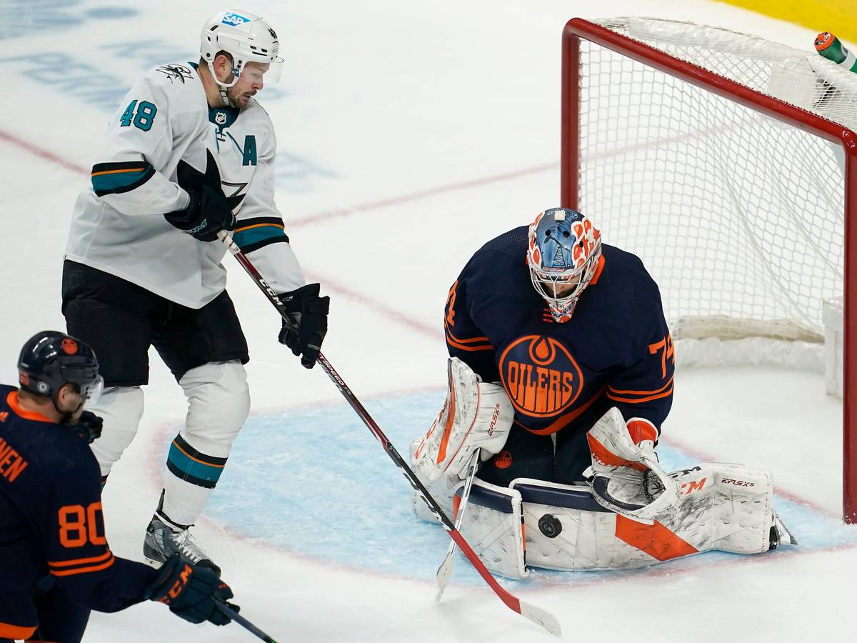 14.02.2022, USA, San Jose: Eishockey: NHL, San José Sharks - Edmonton Oilers, Hauptrunde, Hauptrunde-Partien, 117. Spieltag: Edmonton Oilers-Torwart Stuart Skinner (r) wehrt einen Schussversuch von San Jose Sharks-Center Tomas Hertl (M) ab.