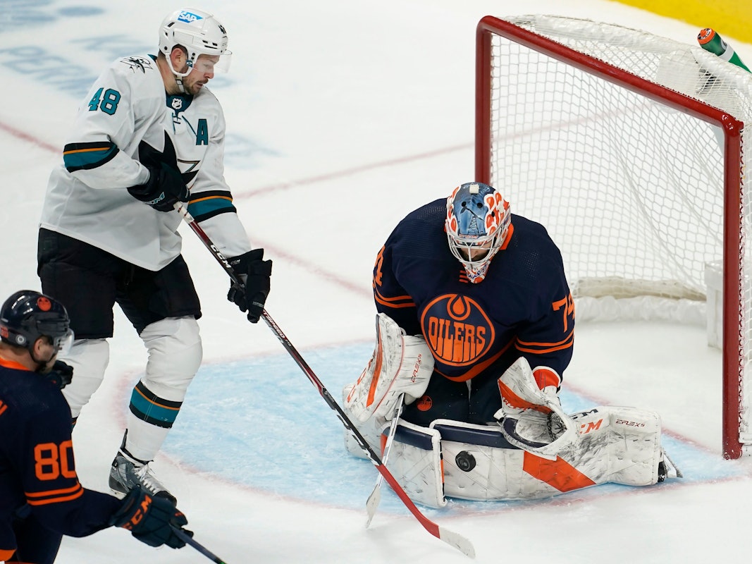 14.02.2022, USA, San Jose: Eishockey: NHL, San José Sharks - Edmonton Oilers, Hauptrunde, Hauptrunde-Partien, 117. Spieltag: Edmonton Oilers-Torwart Stuart Skinner (r) wehrt einen Schussversuch von San Jose Sharks-Center Tomas Hertl (M) ab.