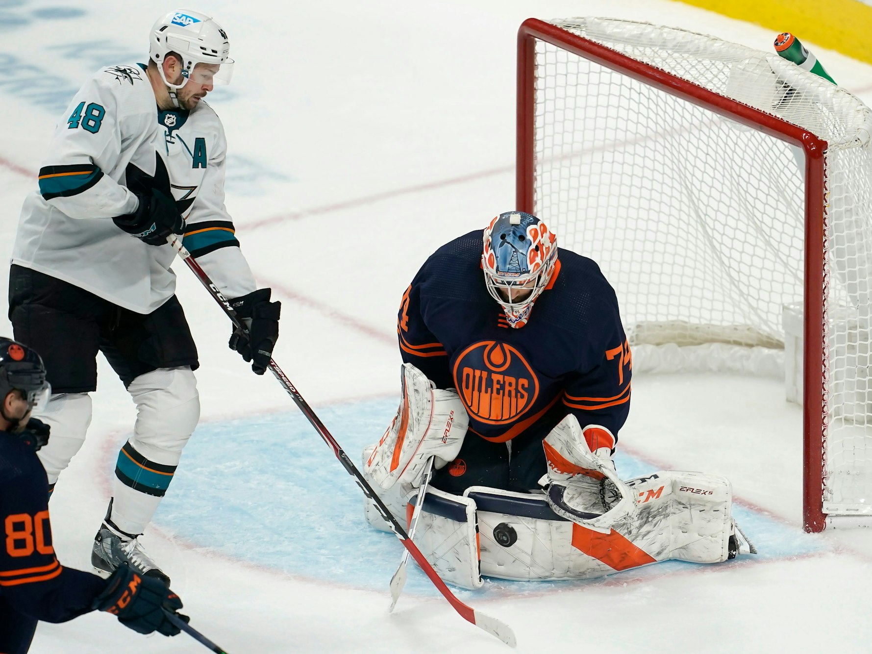 14.02.2022, USA, San Jose: Eishockey: NHL, San José Sharks - Edmonton Oilers, Hauptrunde, Hauptrunde-Partien, 117. Spieltag: Edmonton Oilers-Torwart Stuart Skinner (r) wehrt einen Schussversuch von San Jose Sharks-Center Tomas Hertl (M) ab.