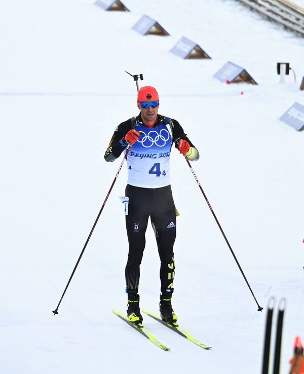 15.02.2022, China, Zhangjiakou: Olympia, Biathlon, Staffel 4 x 7,5 km, Herren, im Nationalen Biathlonzentrum, Philipp Nawrath (l) aus Deutschland steht im Ziel. Rechts jubelt das Team Norwegen. Foto: Hendrik Schmidt/dpa-Zentralbild/dpa +++ dpa-Bildfunk +++