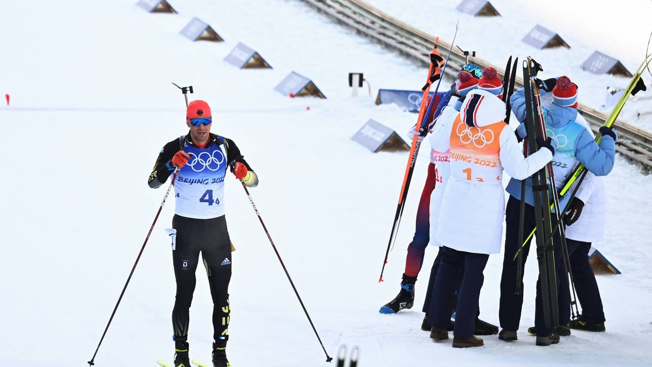 15.02.2022, China, Zhangjiakou: Olympia, Biathlon, Staffel 4 x 7,5 km, Herren, im Nationalen Biathlonzentrum, Philipp Nawrath (l) aus Deutschland steht im Ziel. Rechts jubelt das Team Norwegen. Foto: Hendrik Schmidt/dpa-Zentralbild/dpa +++ dpa-Bildfunk +++