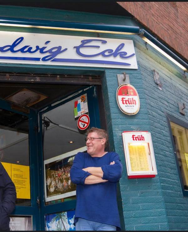 Robert Hilbers steht mit Wolfgang Niedecken am Eingang des Chlodwig Eck.
