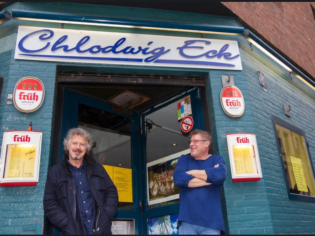 Robert Hilbers steht mit Wolfgang Niedecken am Eingang des Chlodwig Eck.