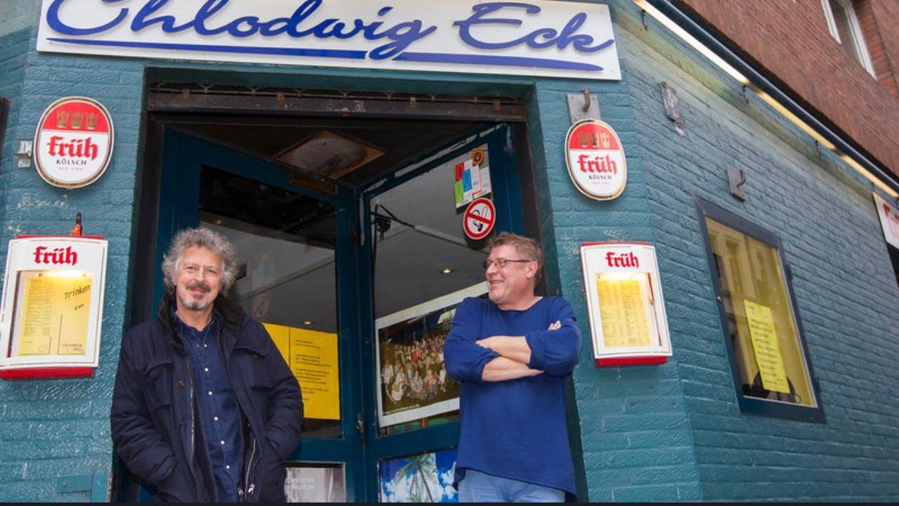 Robert Hilbers steht mit Wolfgang Niedecken am Eingang des Chlodwig Eck.