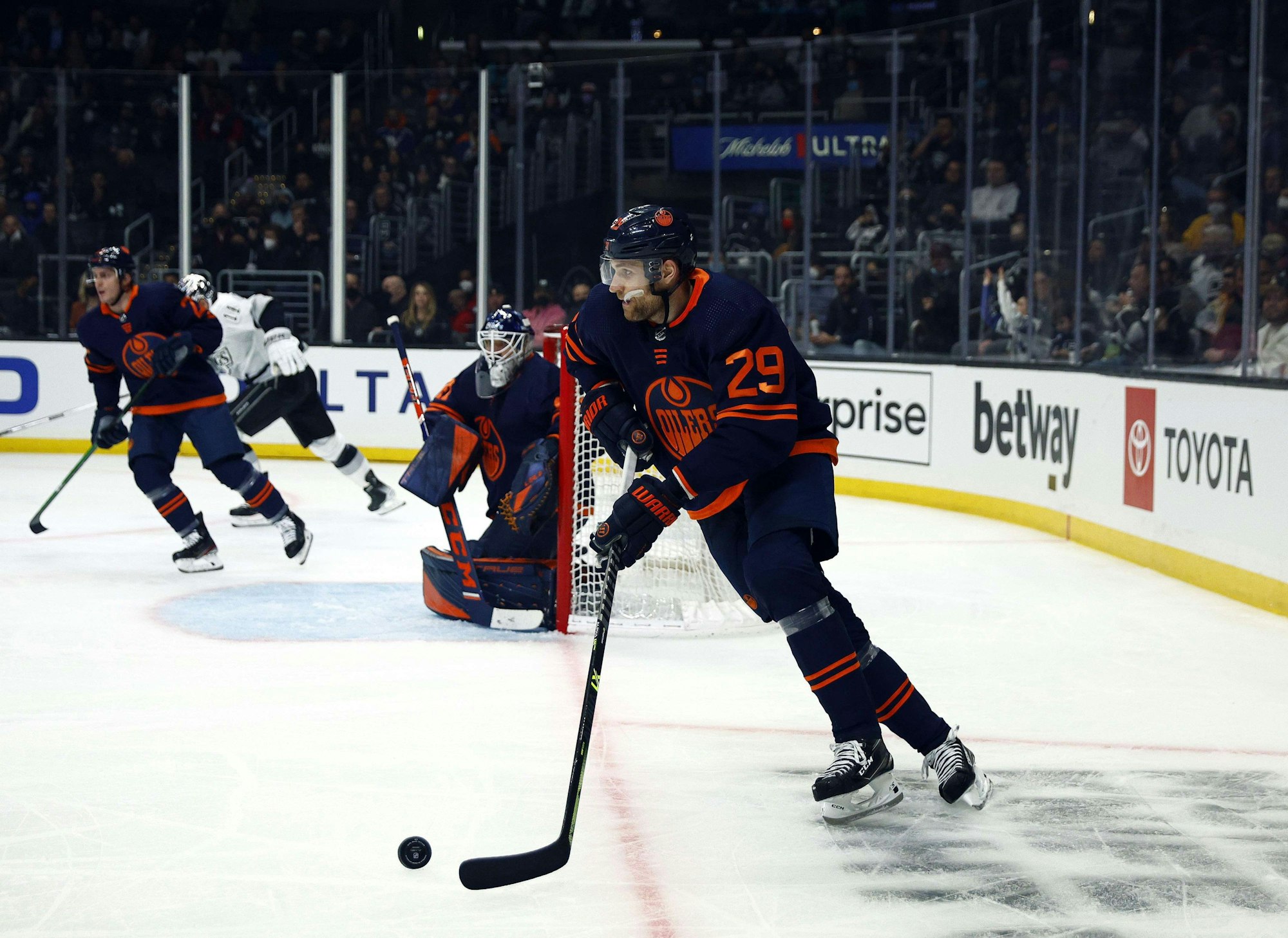 Leon Draisaitl spielt einen Puck.