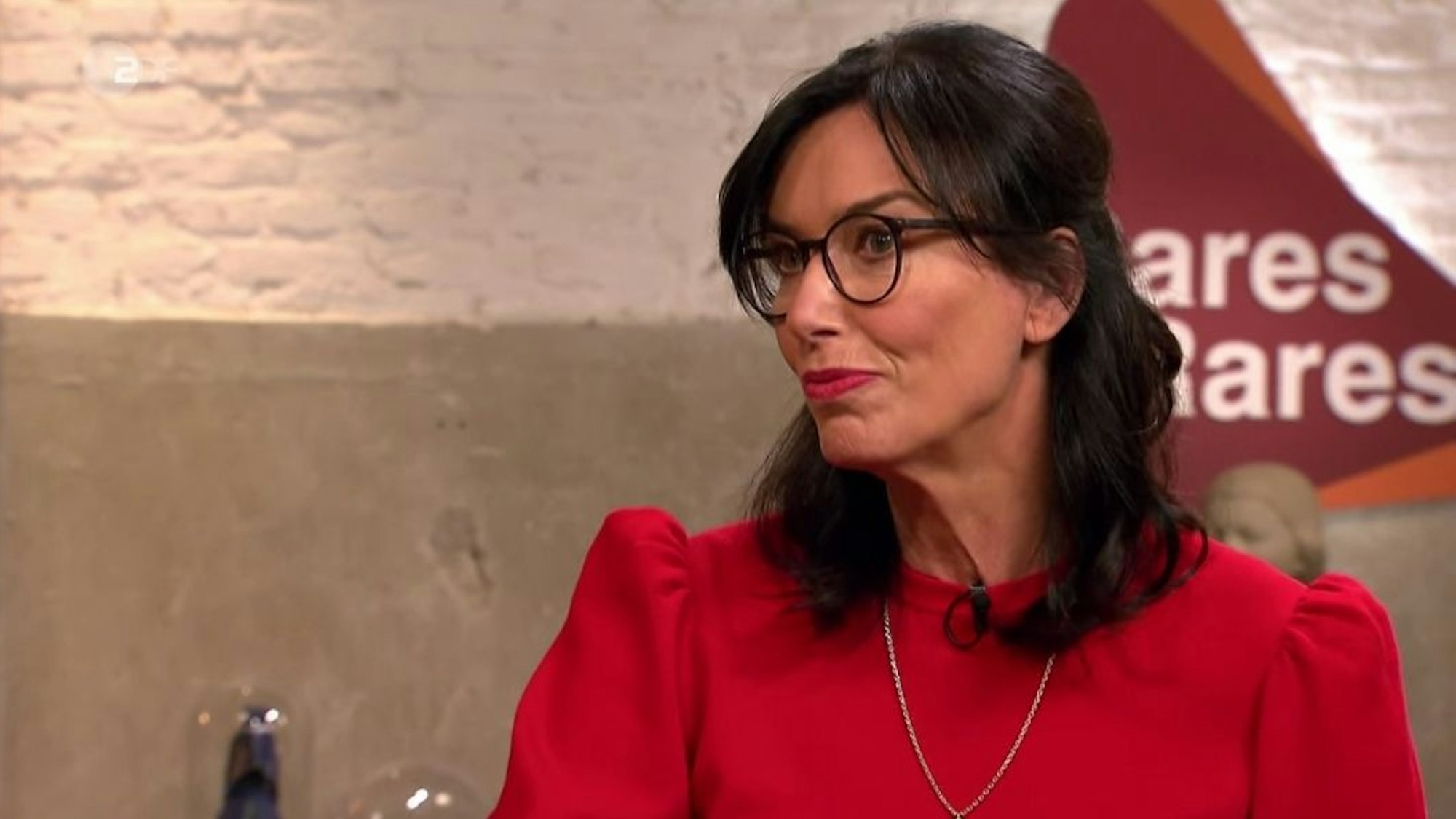 Heide Rezepa-Zabel trägt ein rotes Oberteil.