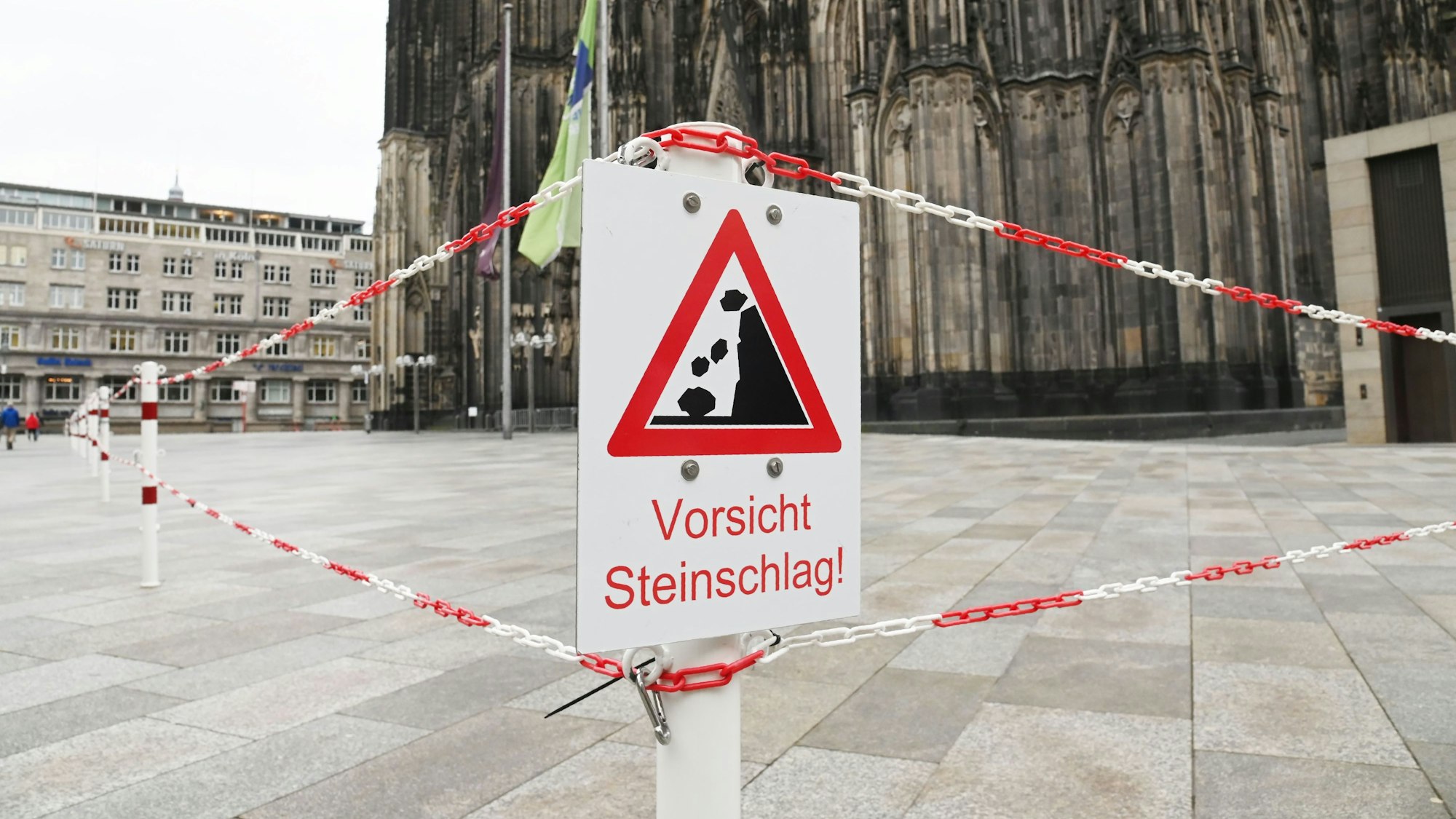 Mitarbeiter des Domes haben am Mittwoch, 16. Februar, Warnschilder mit der Aufschrift „Vorsicht Steinschlag“ auf der Domplatte aufgestellt.