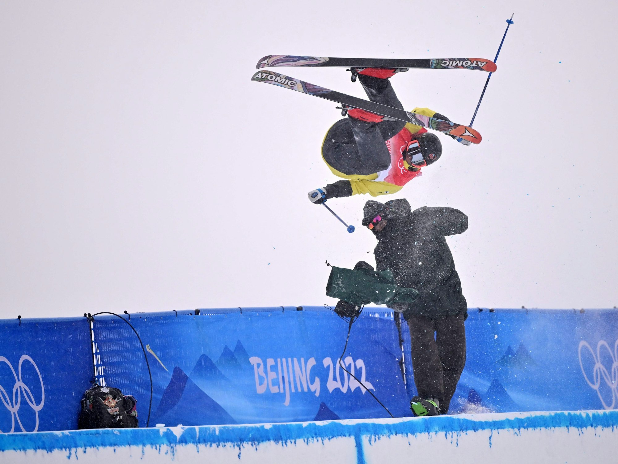 Der Finne Jon Sallinen kracht in der Halfpipe-Qualifikation im Genting Snow Park von Zhangjiakou am 17. Februar 2022 bei einem Sprung mit voller Wucht in einen Kameramann.
