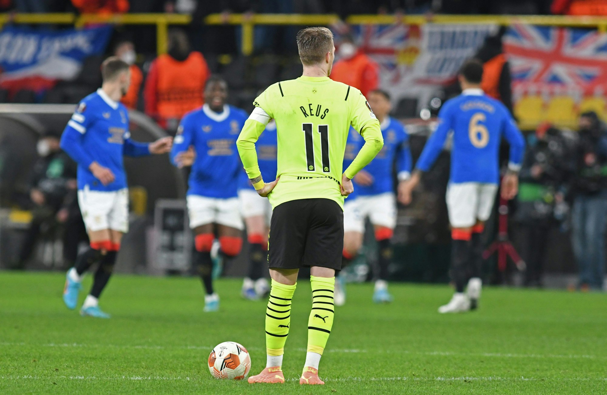 Dortmunds Mittelfeldspieler Marco Reus reagiert auf das 1:4 während im Hintergrund Glasgower Spieler darüber jubeln.