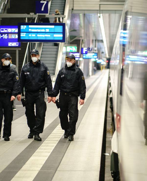 Beamte der Bundespolizei gehen durch einen Bahnhof.