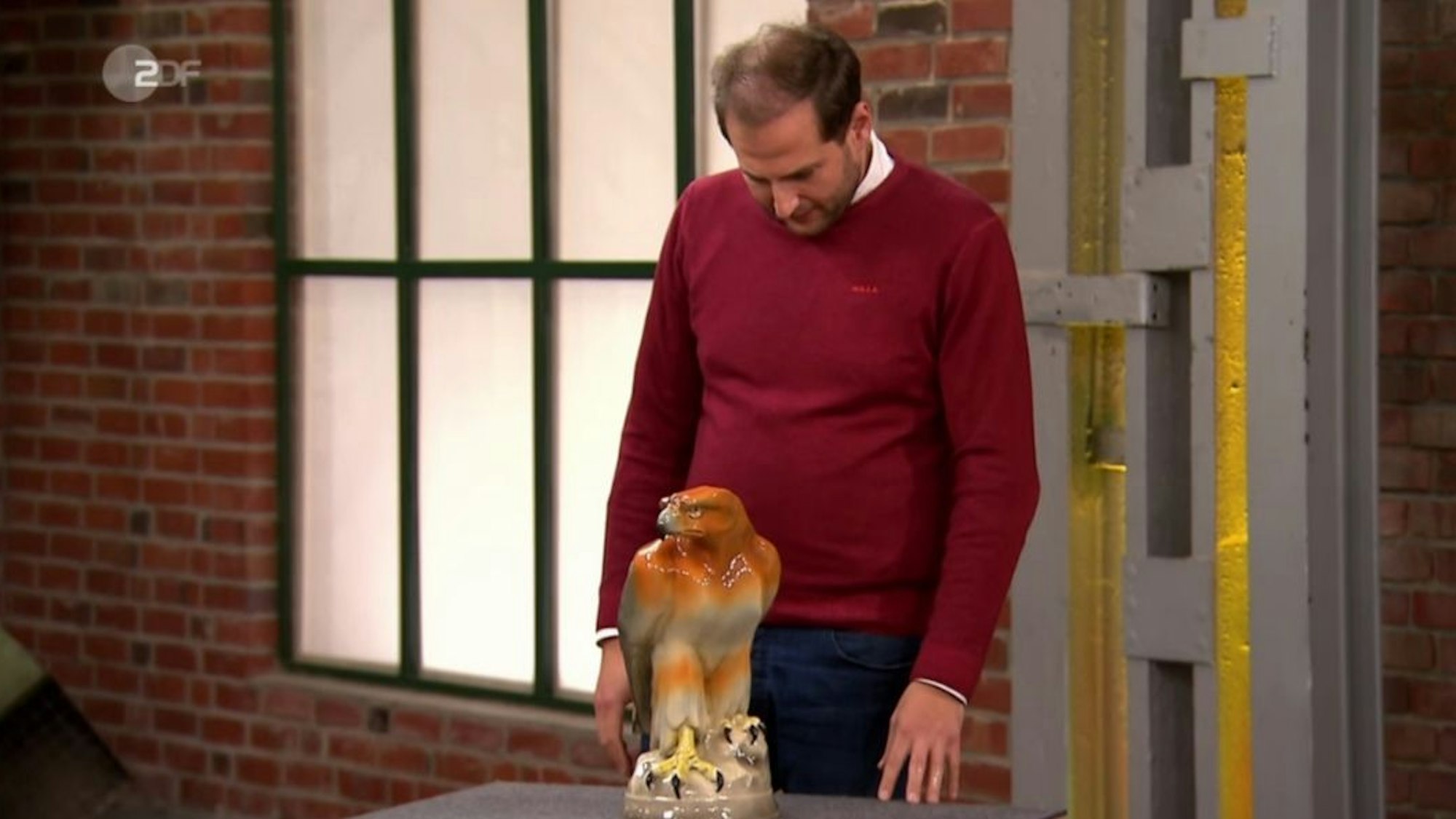 Julian Schmitz-Avila begutachtet einen Steinadler aus Keramik.
Screenshot: ZDF