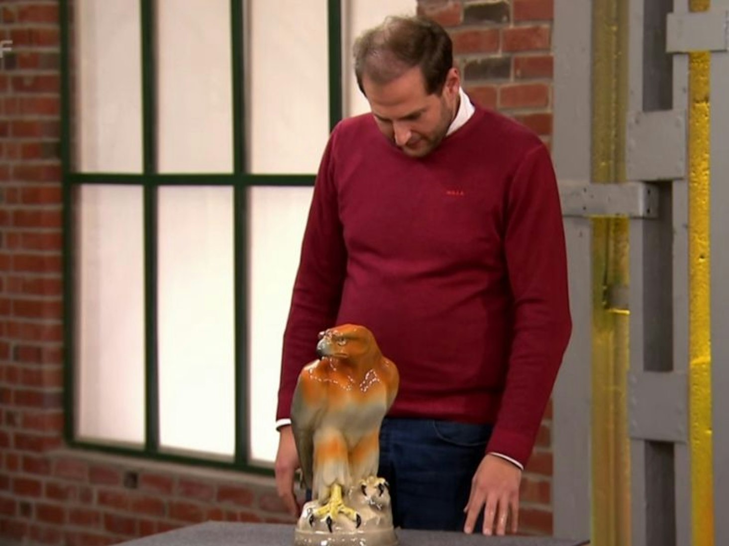 Julian Schmitz-Avila begutachtet einen Steinadler aus Keramik.