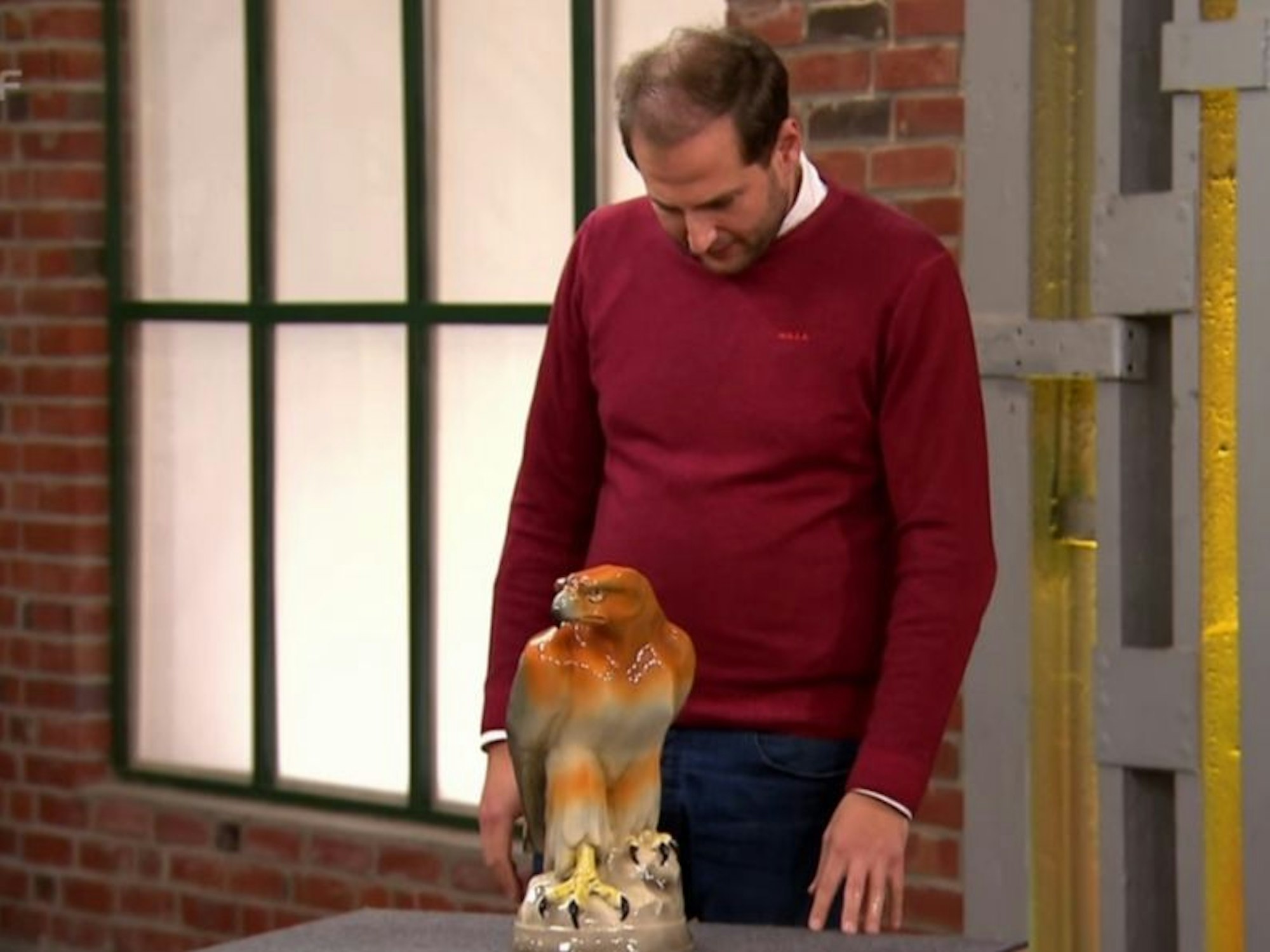 Julian Schmitz-Avila begutachtet einen Steinadler aus Keramik.