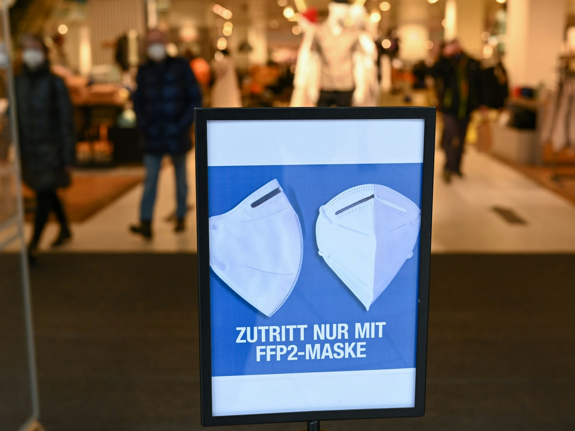 Hinweisschild mit der Aufschrift „Zutritt nur mit FFP 2-Maske“ vor einem Eingang.