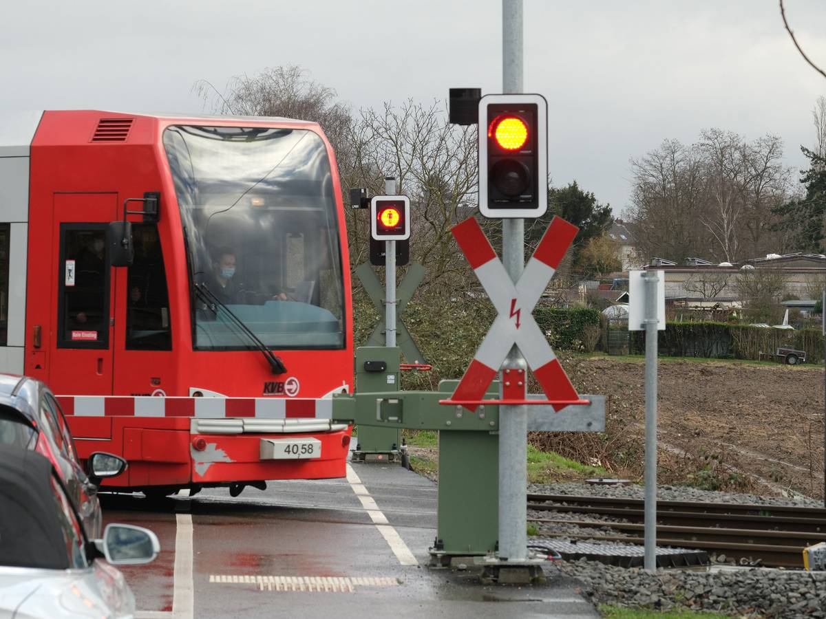 Eine Bahn der KVB passiert auf dem Weg zur Hauptwerkstatt Schienenfahrzeuge an einem Bahnübergang den Simonskaul.