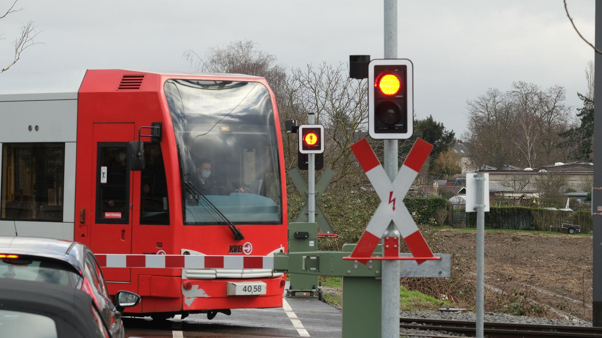 Eine Bahn der KVB passiert auf dem Weg zur Hauptwerkstatt Schienenfahrzeuge an einem Bahnübergang den Simonskaul.