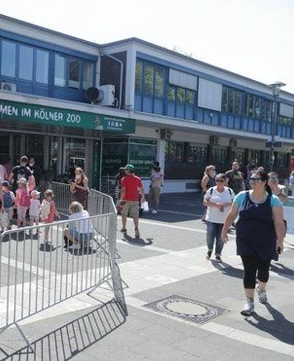 Menschen stehen in einer Warteschlange vor dem Kölner Zoo.