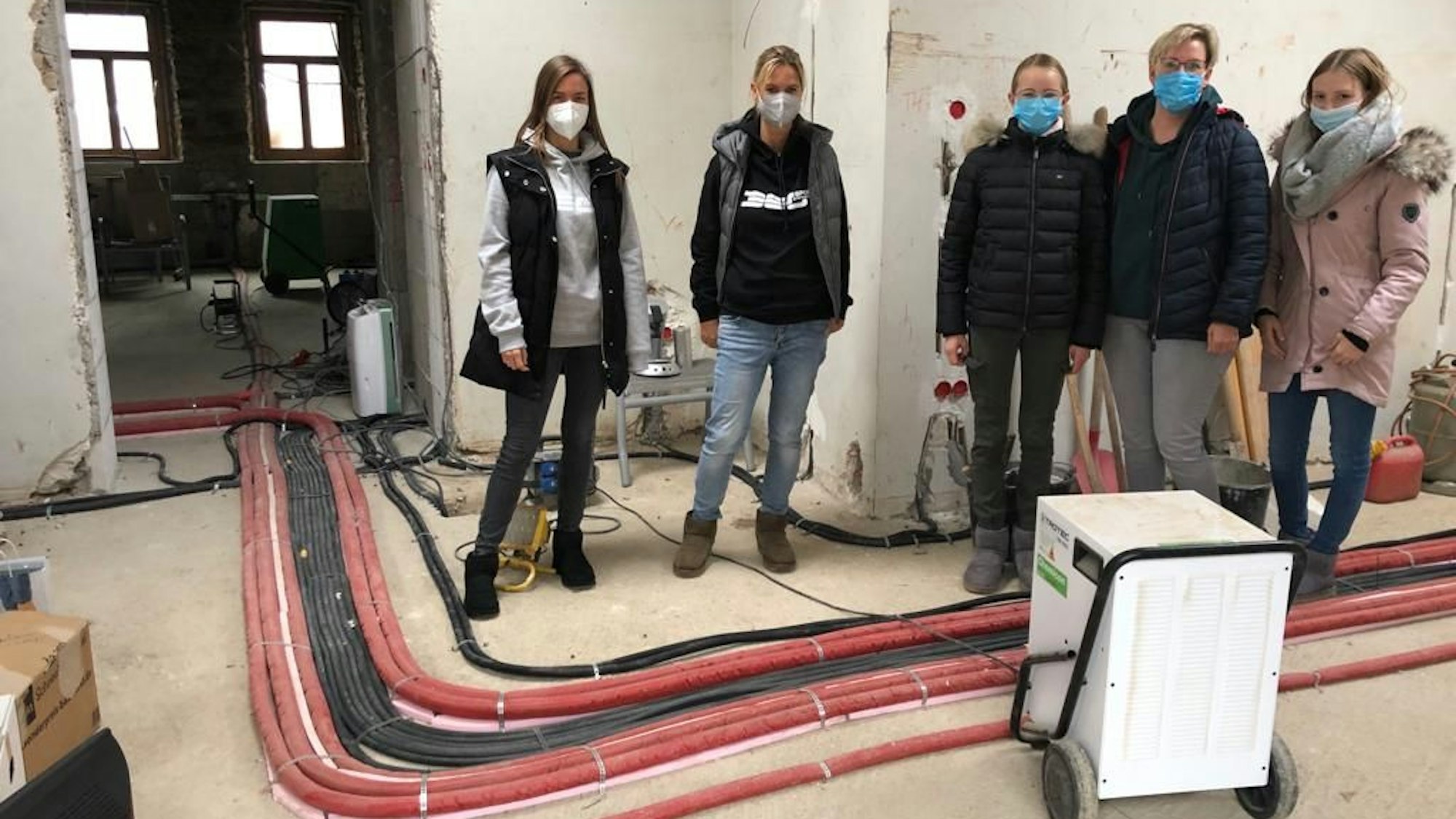 Die Stiftungs-Mitarbeiter stehen in einem Haus.