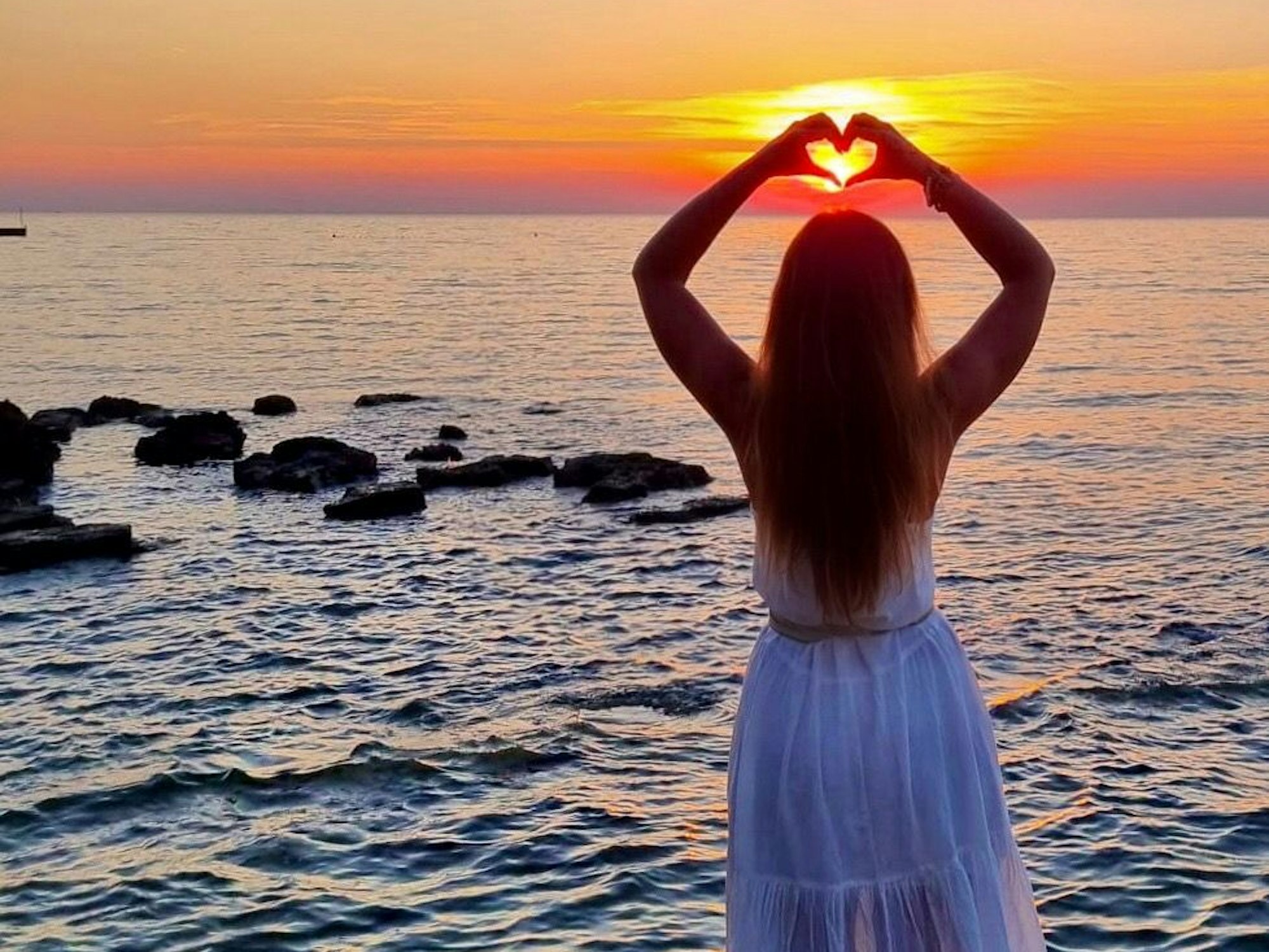 Jessica formt ihren Händen ein Herz.