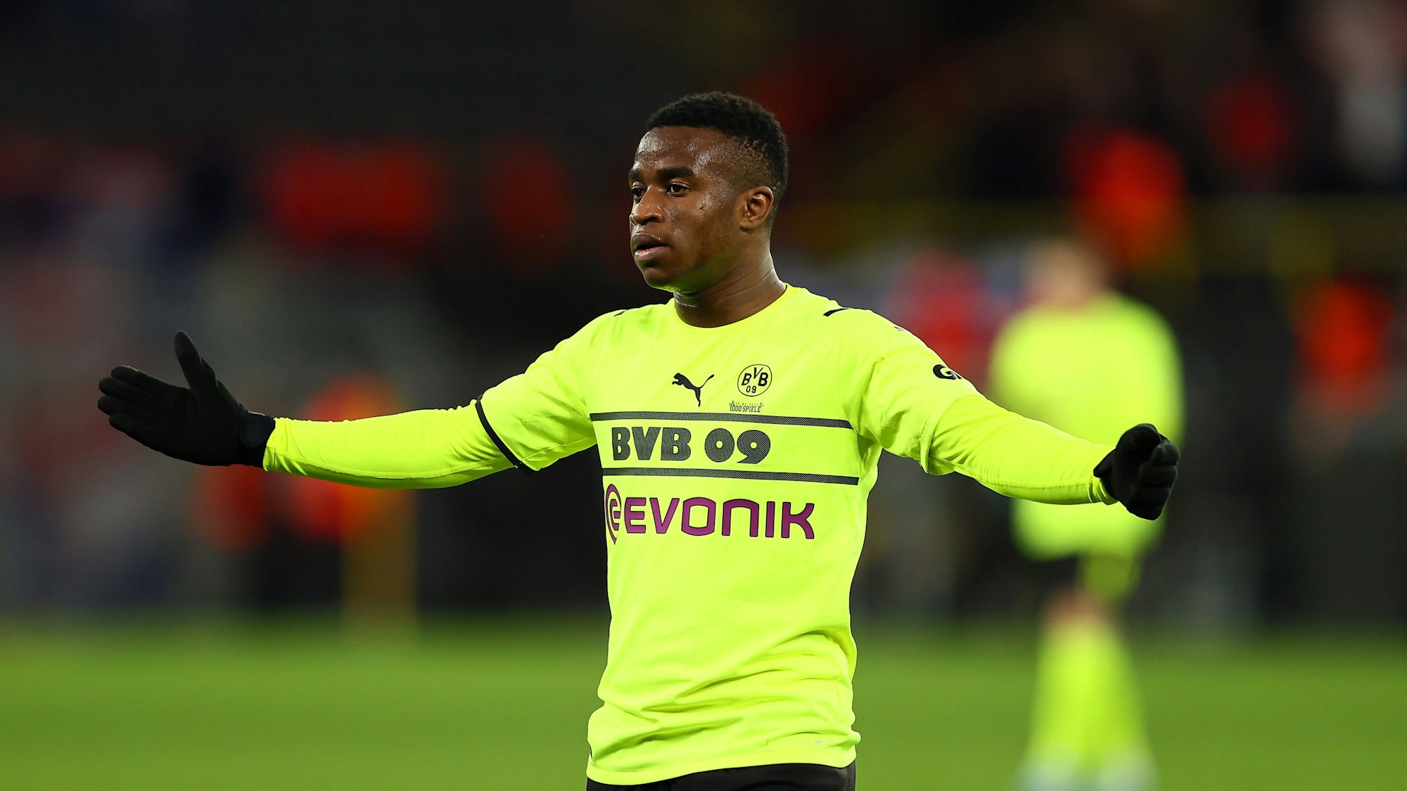 Youssoufa Moukoko breitet die Arme aus.