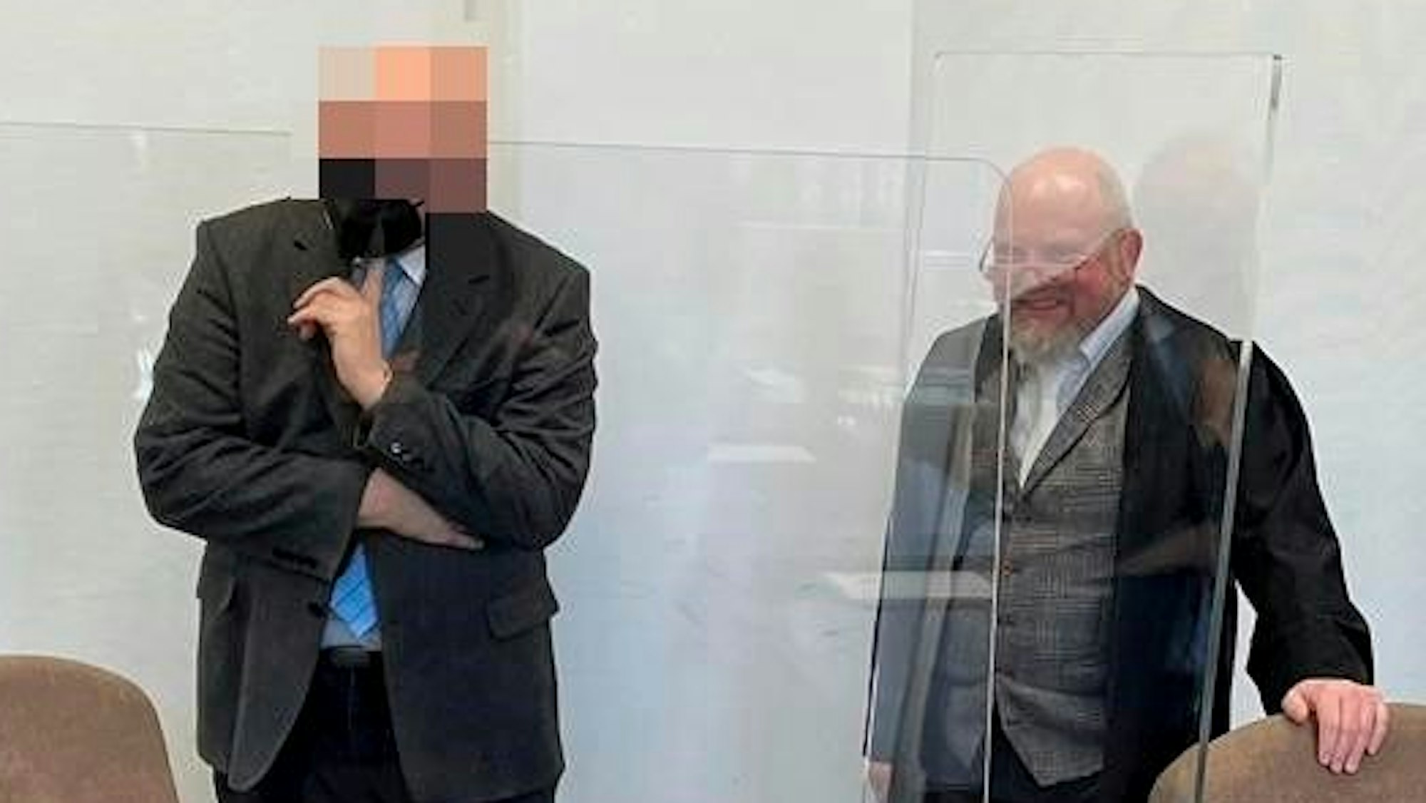 Ein ehemaliger Oberstaatsanwalt steht im Gerichtssaal neben seinem Verteidiger.