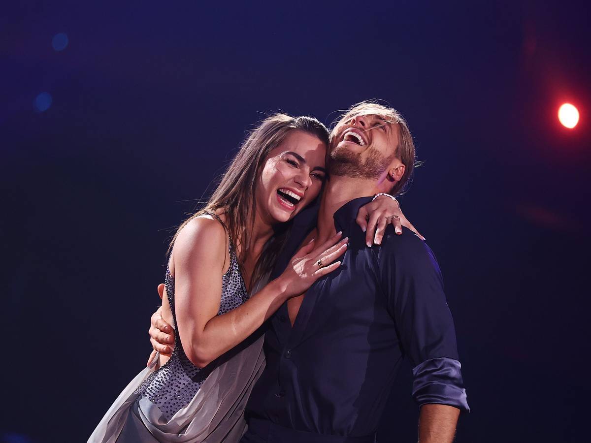 Der Fußballer Rurik Gislason und Profitänzerin Renata Lusin lachen bei der RTL-Tanzshow "Let's Dance" auf der Bühne.