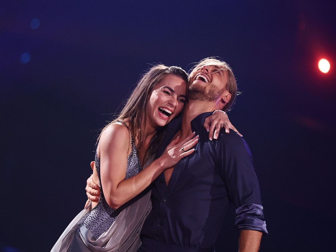 Der Fußballer Rurik Gislason und Profitänzerin Renata Lusin lachen bei der RTL-Tanzshow "Let's Dance" auf der Bühne.