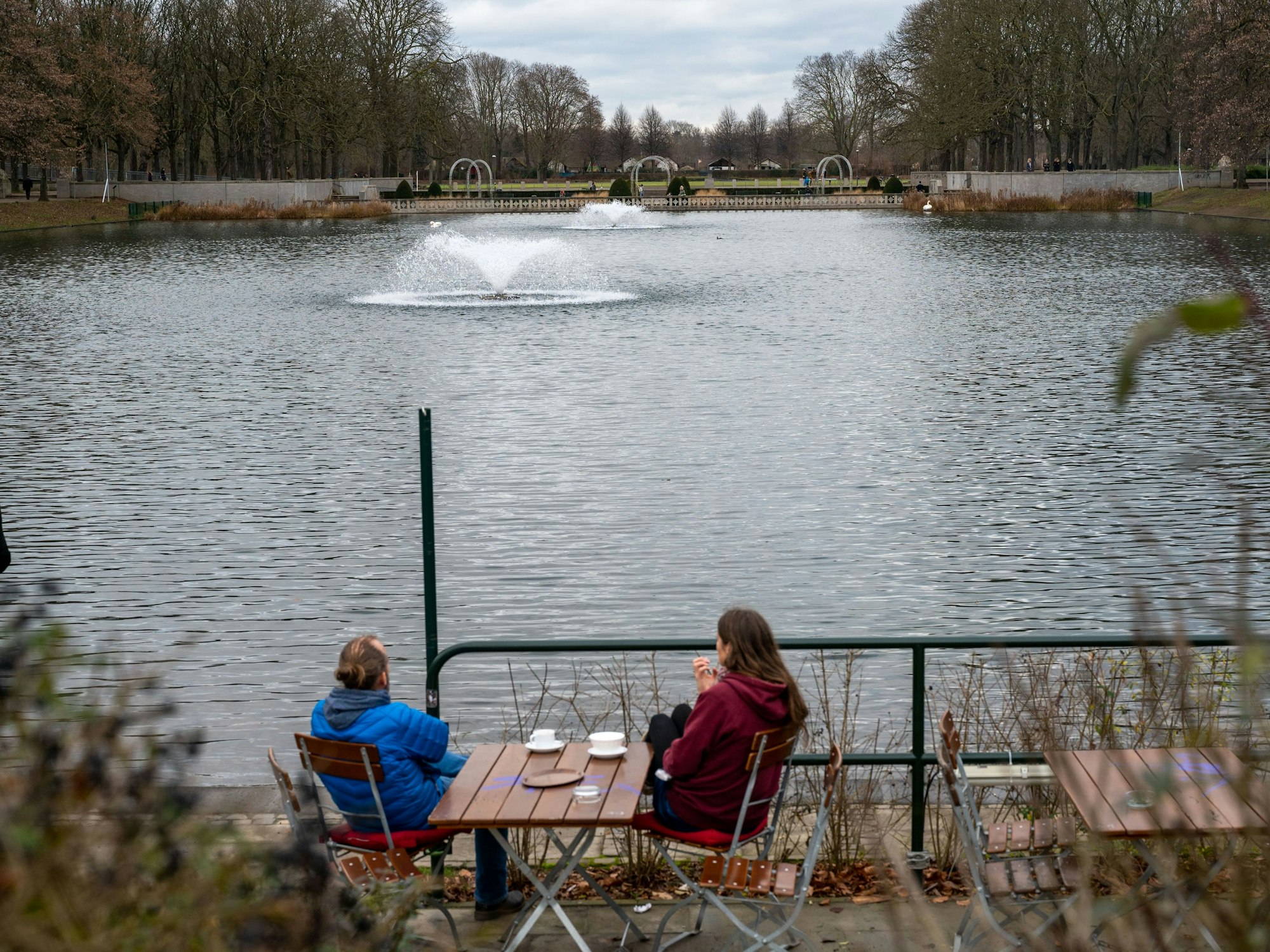 Zwei Menschen in einem Café am Wasser im Blücherpark.