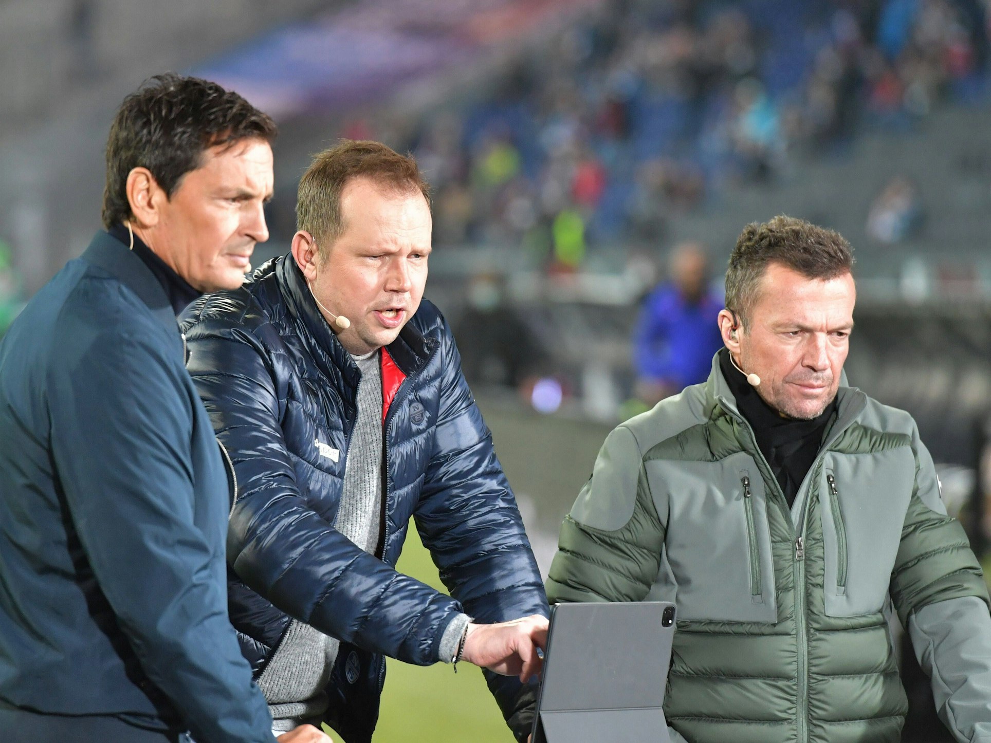 Wolff-Christoph Fuss (Mitte) zusammen mit Sebastian Hellmann (l.) und Lothar Matthäus vor einem Tablet.