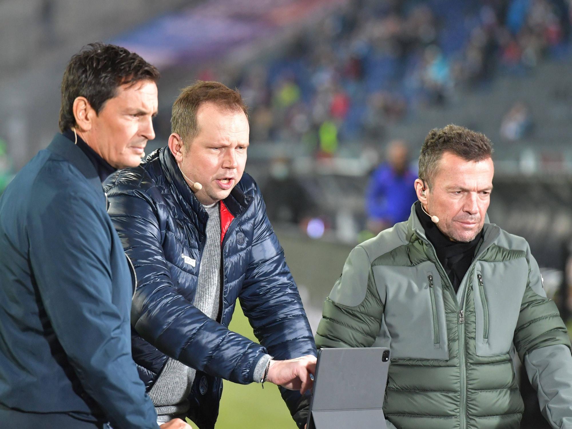 Wolff-Christoph Fuss (Mitte) zusammen mit Sebastian Hellmann (l.) und Lothar Matthäus vor einem Tablet.