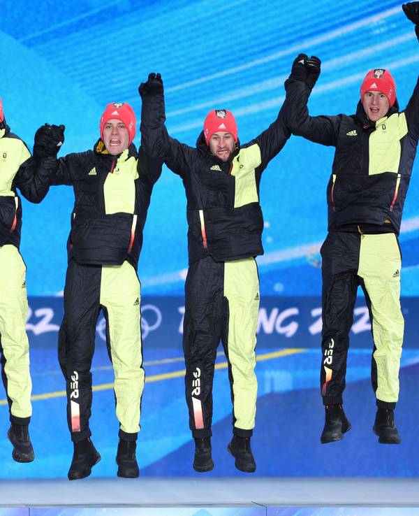 Constantin Schmid, Stephan Leyhe, Markus Eisenbichler und Karl Geiger hüpfen auf dem Podium bei Olympia.