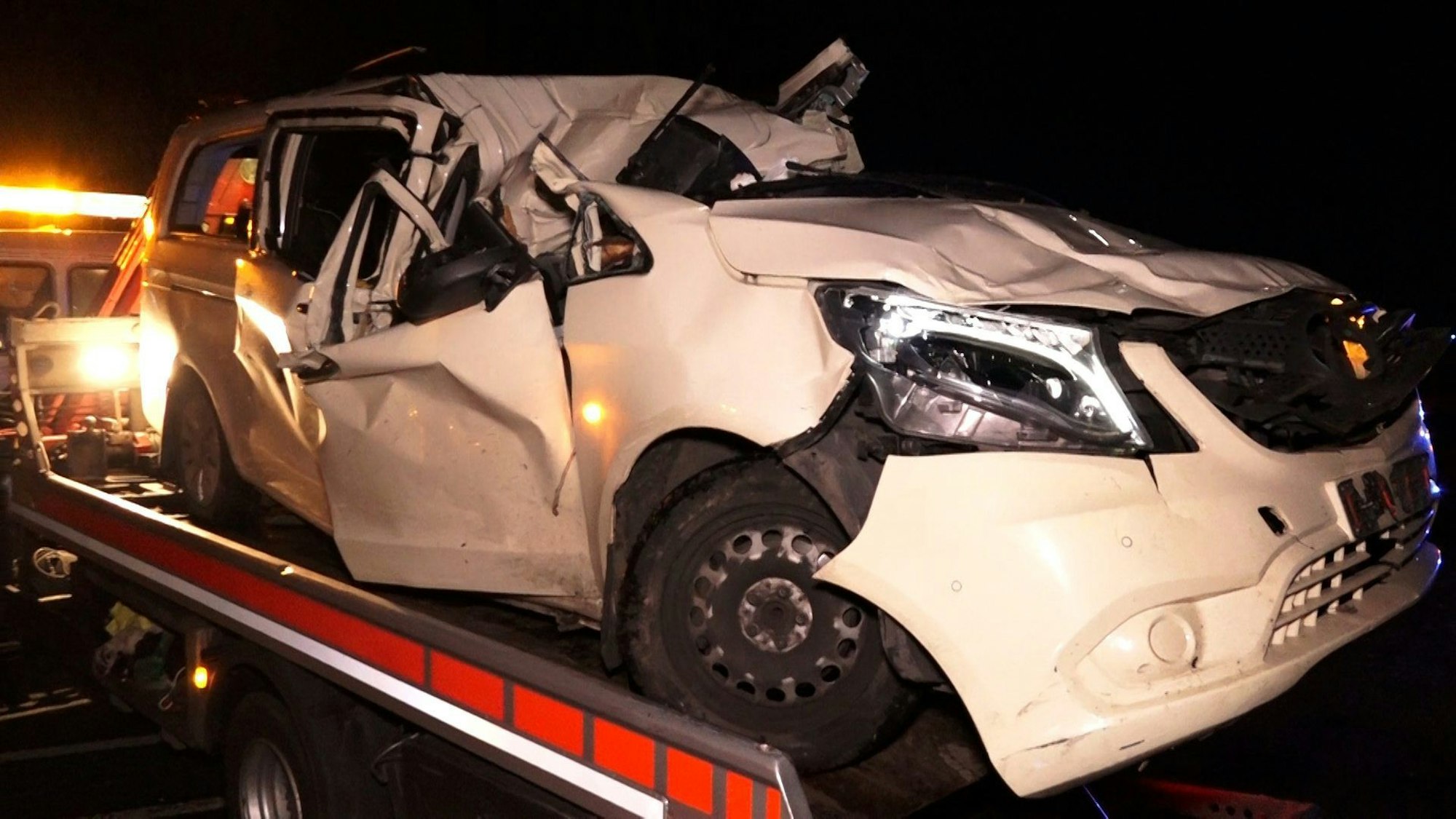 Ein zerstörtes Auto steht auf einem Transporter.