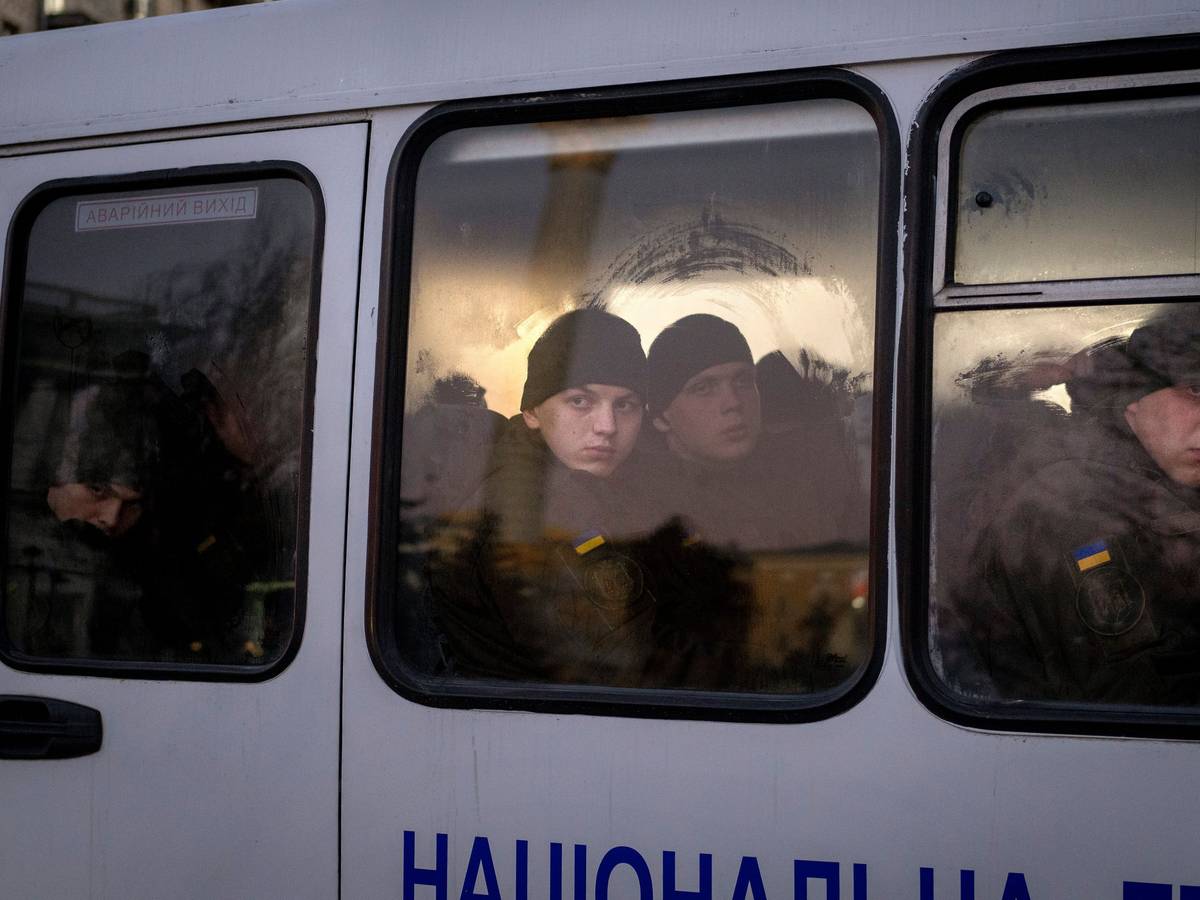 Mitglieder der ukrainischen Nationalgarde schauen Mitte Februar aus dem Fenster, während sie in einem Bus durch Kiew fahren. Die Lufthansa streicht Flüge von und nach Kiew, das Auswärtige Amt ruft alle Deutschen dazu auf, das Land zu verlassen.