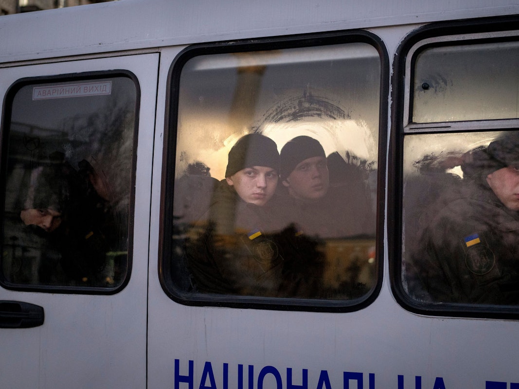 Mitglieder der ukrainischen Nationalgarde schauen Mitte Februar aus dem Fenster, während sie in einem Bus durch Kiew fahren. Die Lufthansa streicht Flüge von und nach Kiew, das Auswärtige Amt ruft alle Deutschen dazu auf, das Land zu verlassen.