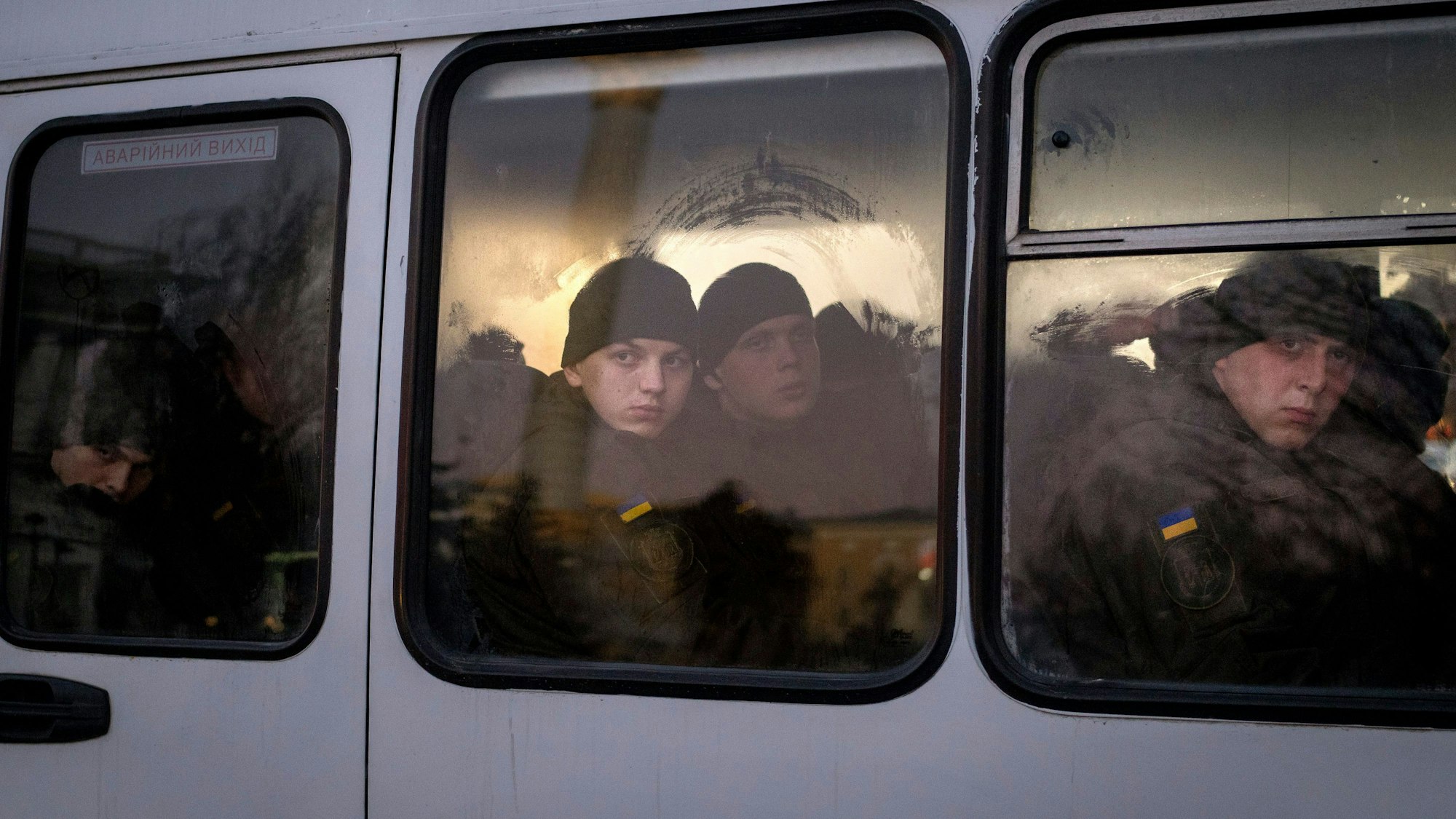 Mitglieder der ukrainischen Nationalgarde schauen Mitte Februar aus dem Fenster, während sie in einem Bus durch Kiew fahren. Die Lufthansa streicht Flüge von und nach Kiew, das Auswärtige Amt ruft alle Deutschen dazu auf, das Land zu verlassen.