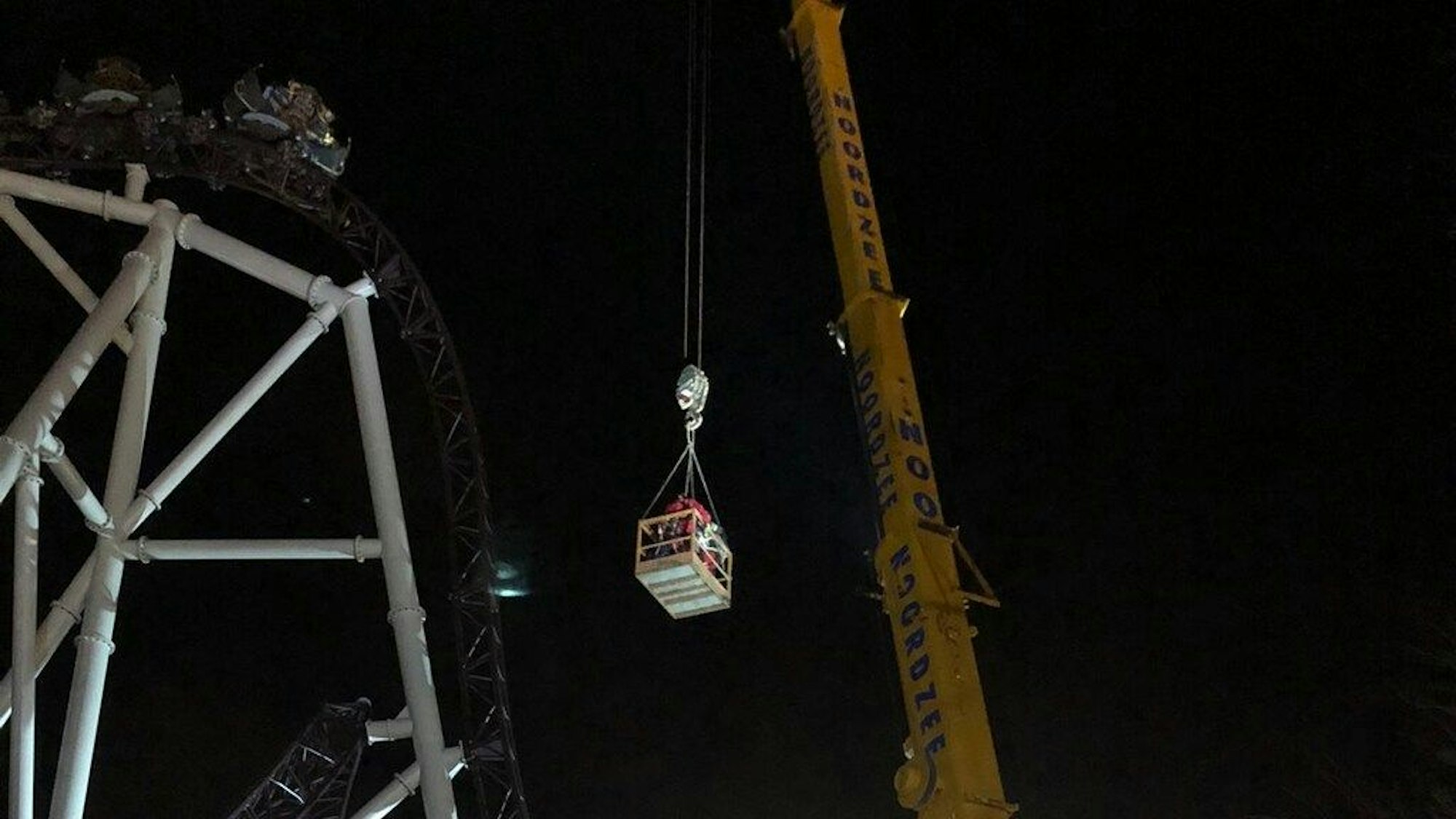 Dieses Foto von den Rettungskräften zeigt den Versuch, die gestrandeten Fahrgäste mithilfe eines Krans aus der Achterbahn zu befreien.