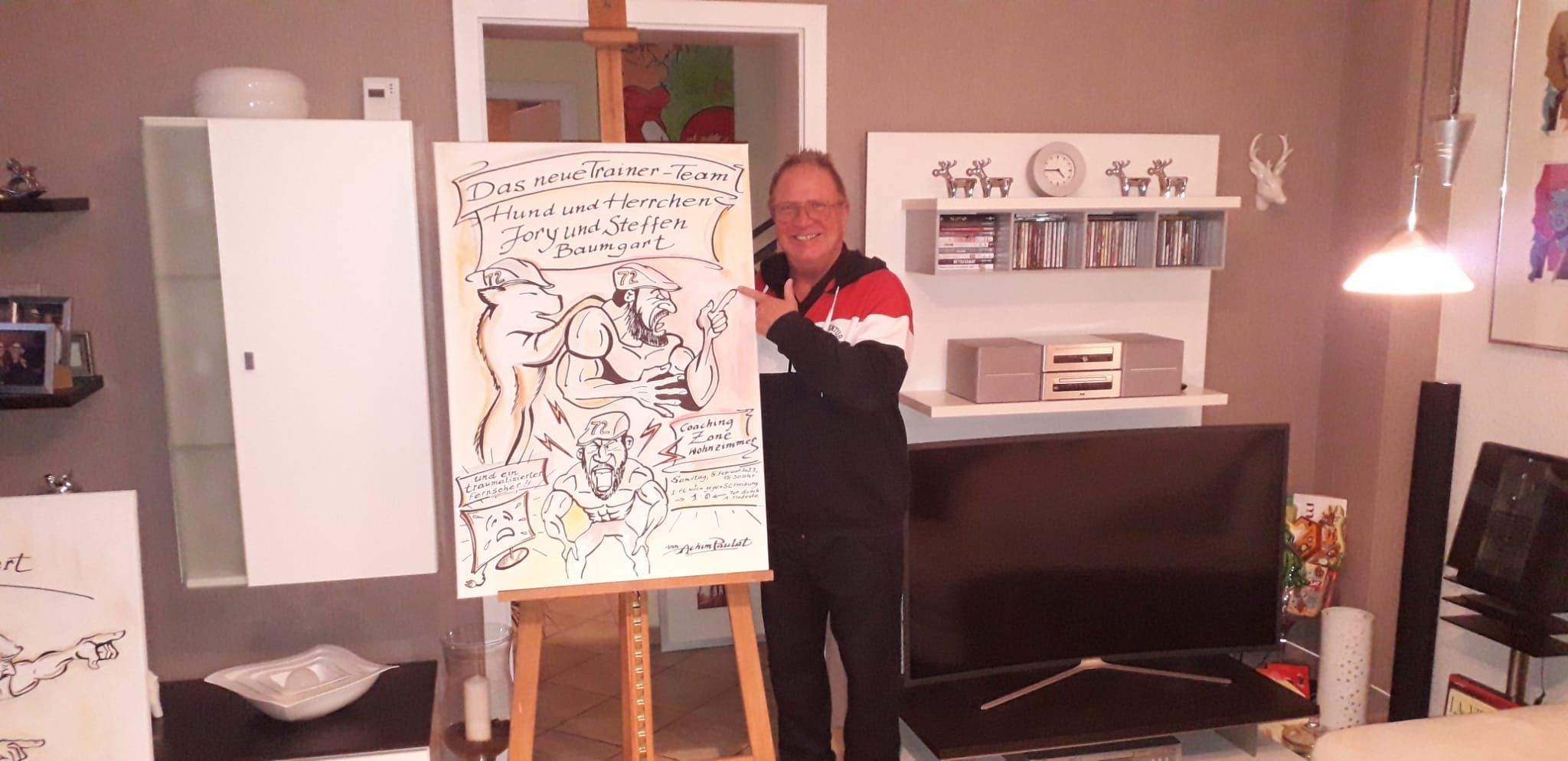 Der Kölner Künstler Achim Paulat posiert neben seinem Kunstwerk von FC-Trainer Steffen Baumgart.