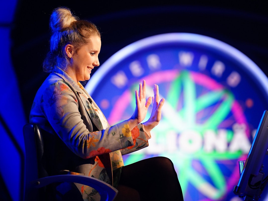 „Wer wird Millionär?“-Kandidatin Anne Kunde sitzt im Studio und freut sich über eine richtige Antwort.