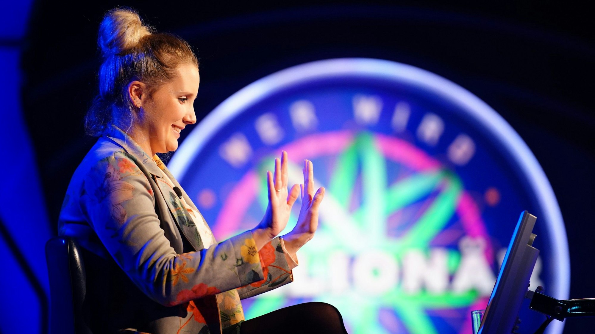 „Wer wird Millionär?“-Kandidatin Anne Kunde sitzt im Studio und freut sich über eine richtige Antwort.